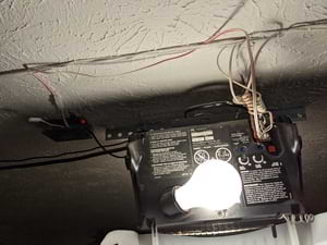 Mounted case with wires attached to garage door opener terminals
