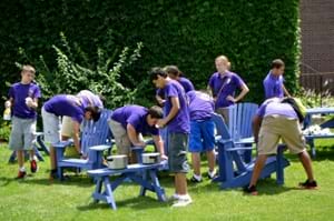 <b>Volunteering </b><br /> University of Success students paint chairs during a volunteer project.