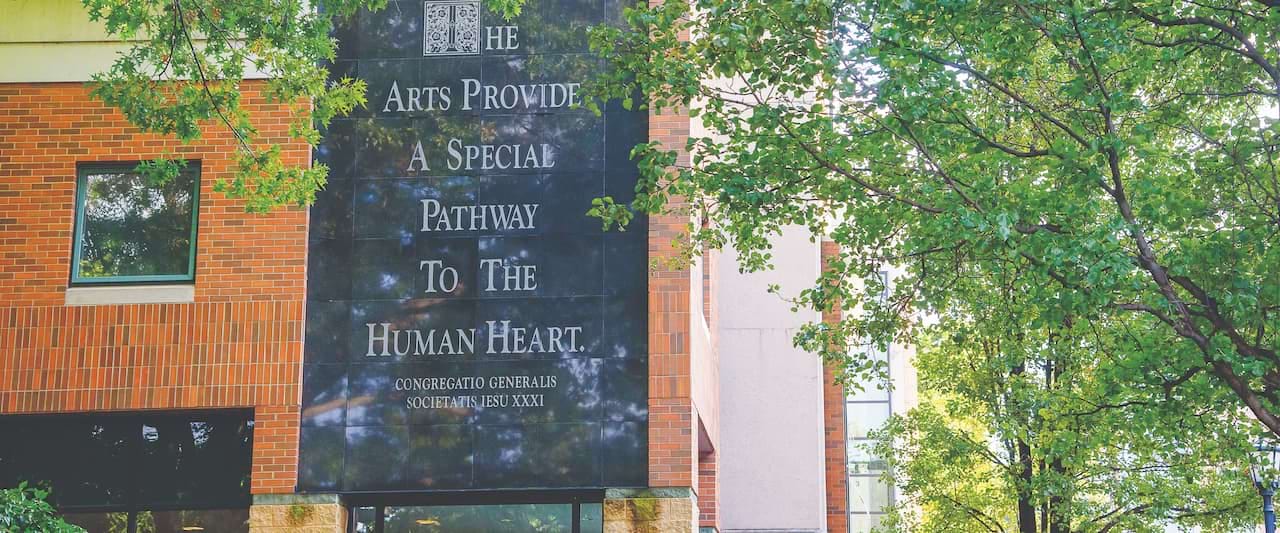 <b>Ariel view of Campus on a sunny day</b><br /> The etched marble entrance of The McDade Center with a quote reading "The Arts Provide a special pathway to the human heart" quoted by Congregatio Generalis Societatis Iesu XXXI