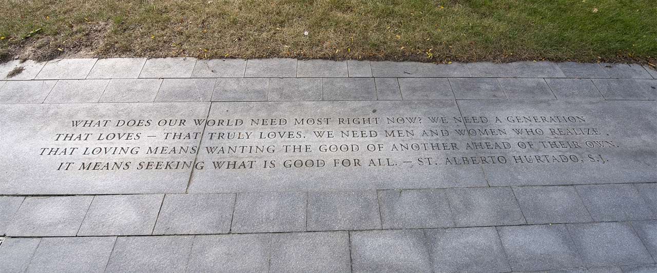 Seals quote on a walkway, "What does our world need most right now? We need a generation that truly loves. We need men and women who realize that loving means wanting the good of another ahead of their own. It means seeking what is good for all." by St. Alberto Huertas. 