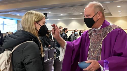 Rev. Daniel Sweeney, S.J., Ph.D., assistant professor of Political Science at the University, administers ashes at a 2022 Ash Wednesday Mass.