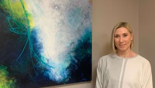 woman standing with abstract painting